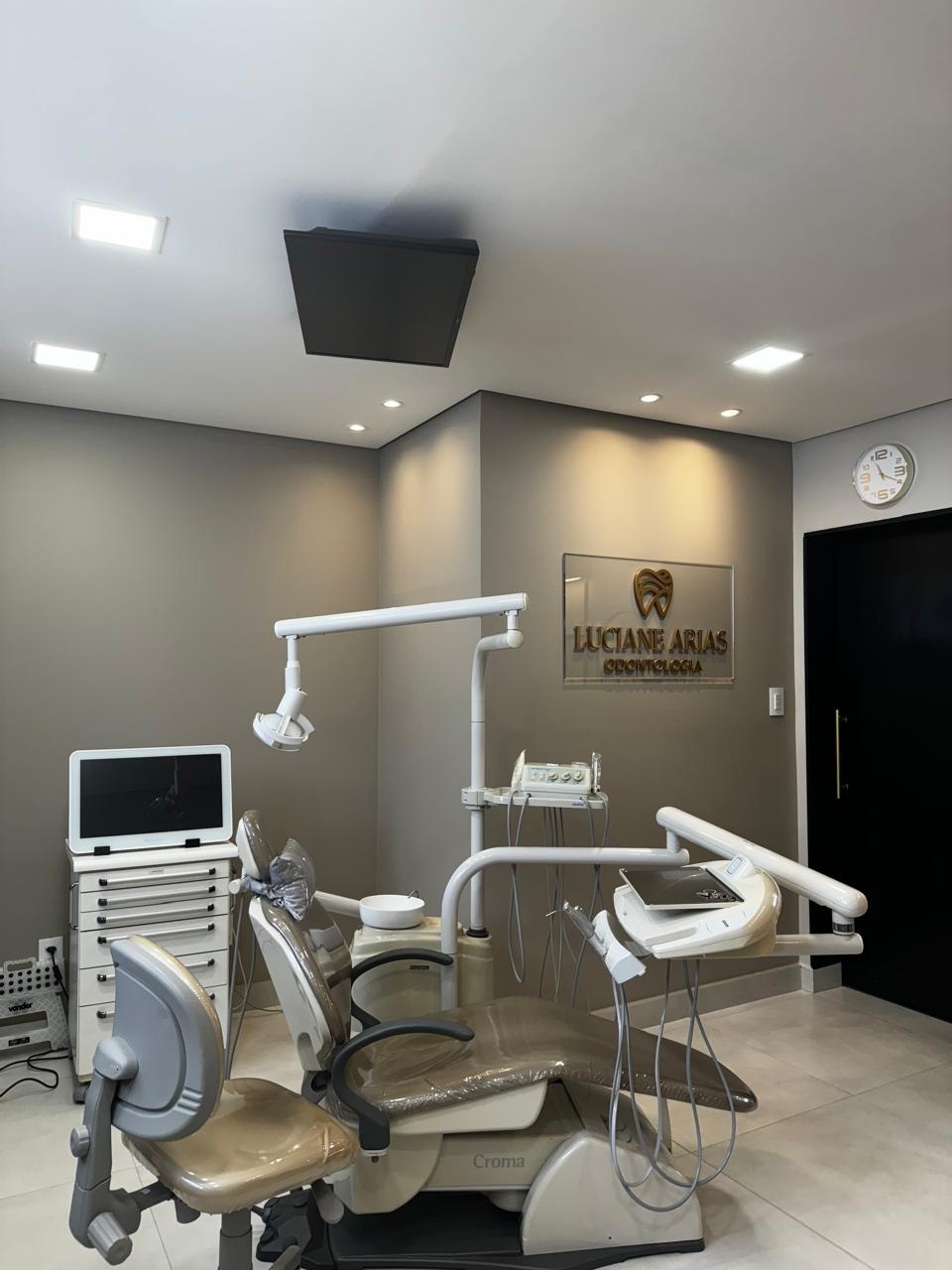 Visão da sala de atendimento com cadeira odontológica, equipamentos e iluminação